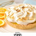 a vegan lemon meringue pie with golden-tipped blow torched meringue on top, and with lemon slices on sides