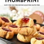 a stack of almond flour thumbprint cookies with the one on top half bitten showing the chewy texture of the cookie