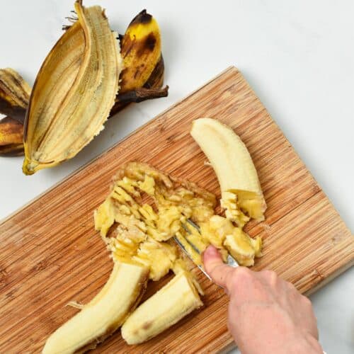 Mashing banana on a chopping board.