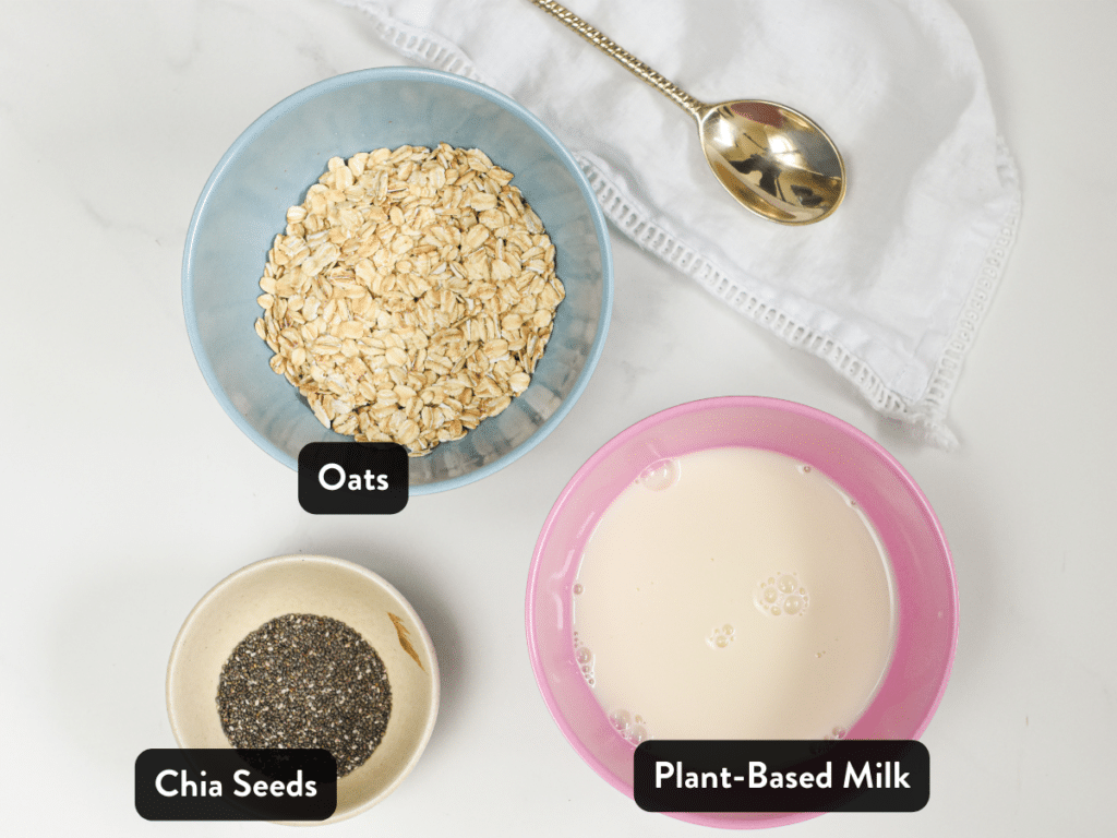 Ingredients for Overnight Oats in bowls next to a golden spoon.