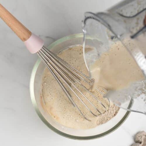 Pouring liquid ingredients on the vegan oatmeal pancake dry ingredients