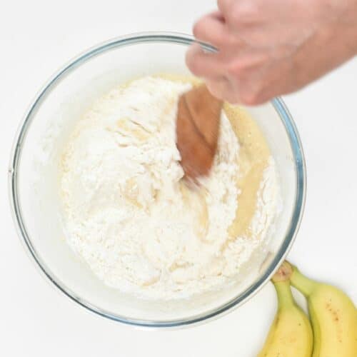 Stirring Sugar-Free Banana Muffin batter in a bowl.