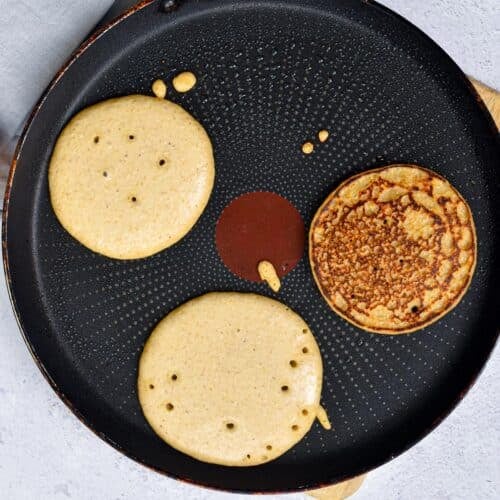 Vegan Almond Flour Pancakes cooking on a pancake griddle