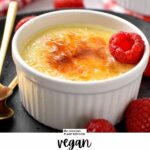 a ramekin filled with a creme brulee mixture topped with crunchy caramel golden layer and a fresh raspberry on side