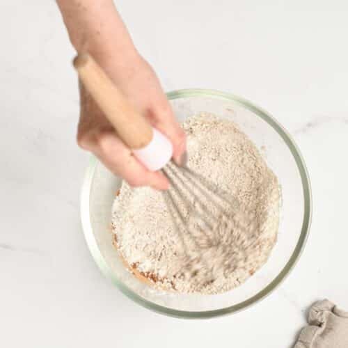 Stirring dry ingredients in a mixing bowl.