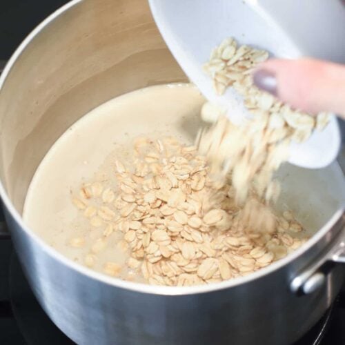 Adding the protein powder and oat mix to a saucepan.