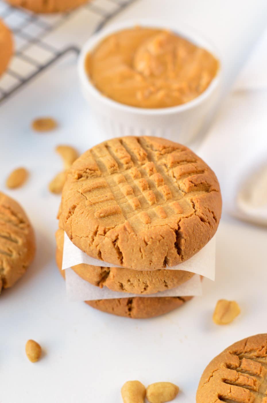 3-Ingredient Peanut Butter Cookies stacked on a white benchtop.