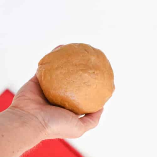3-Ingredient Peanut Butter Cookie dough ball held in the hand.
