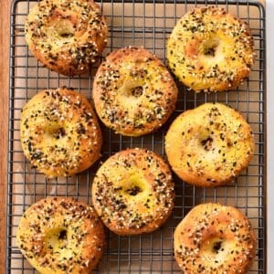 a picture from above with bagels on a cooling rack and topped with bagels seasonings