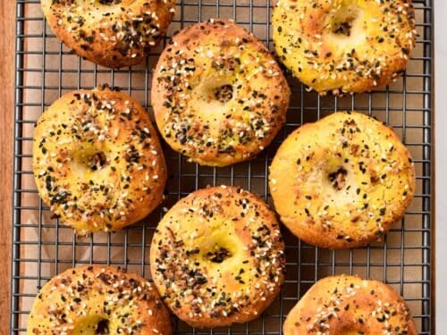 a picture from above with bagels on a cooling rack and topped with bagels seasonings