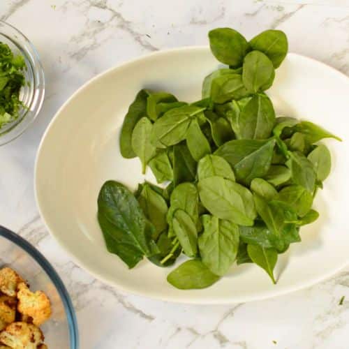 Spinach leaves in a serving bowl.