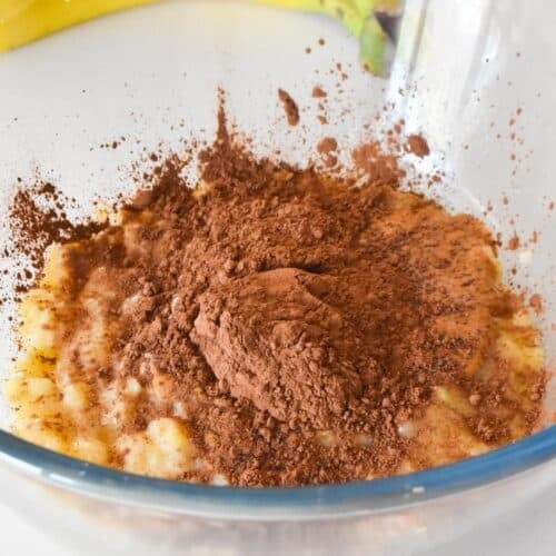 a bowl with mashed banana, peanut butter and cocoa powder