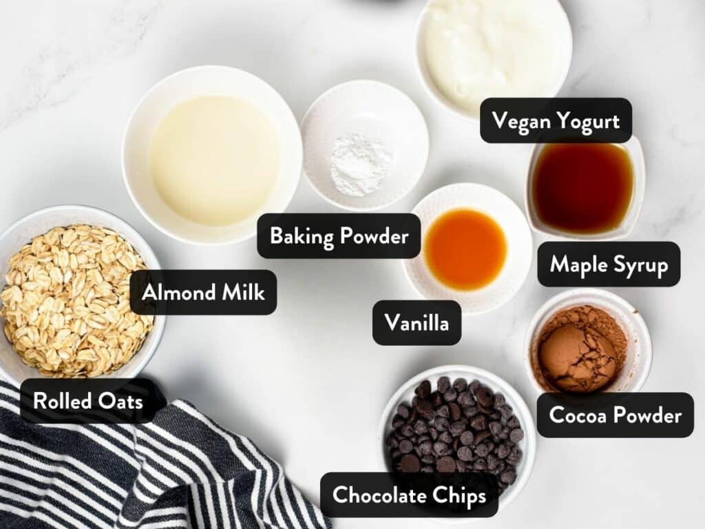 Ingredients for Chocolate Baked Oats in various bowls and ramekins.