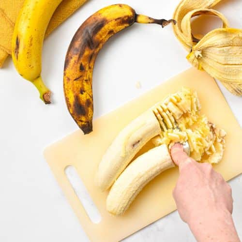 Mashing bananas on a chopping board.