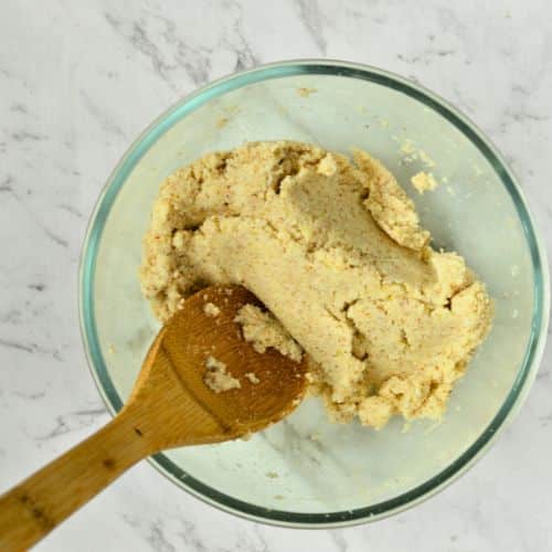 Vegan Gluten-Free Tortilla batter in a mixing bowl with a wooden spoon.