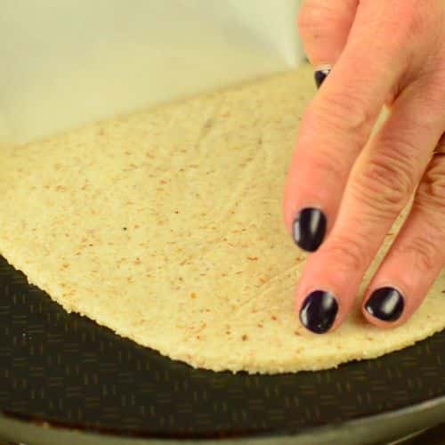 Placing a Vegan Gluten-Free Tortilla on a crepe pan.