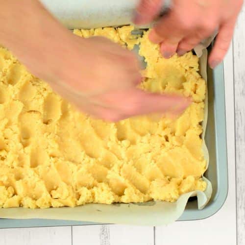 Pressing the Vegan Millionaire Shortbread crust in a pan.