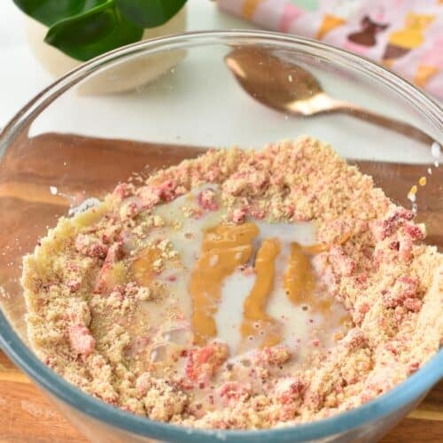 a bowl with the ingredients of strawberry protein balls before mixing