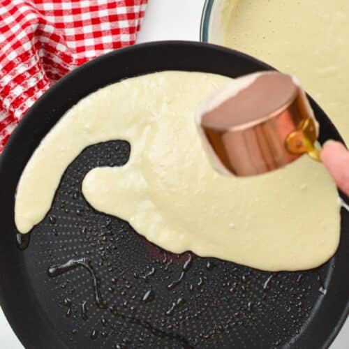 Spreading vegan crepe batter on a pancake pan.