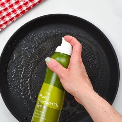 Spraying oil on a crepe pan.