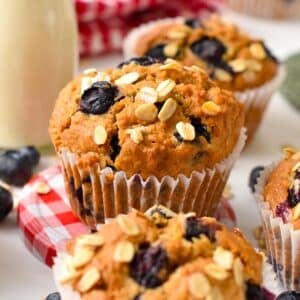 a vegan oatmeal muffin with blueberries,oats on top and placed on red and white round lid