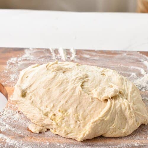 a soft bread dough on a floured wooden surface