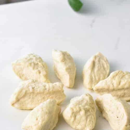 A ball of donut dough cut into small triangles.