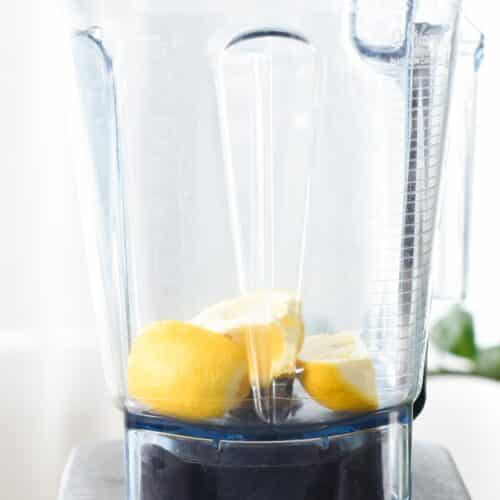 A blender jug with a lemon inside.