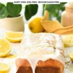 a glaze lemon pound cake on a chopping board with lemons and green plants in the background