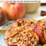 a blue plate with mint leaves on sides of air fried half peaches topped with oat crisp and peaches in the background