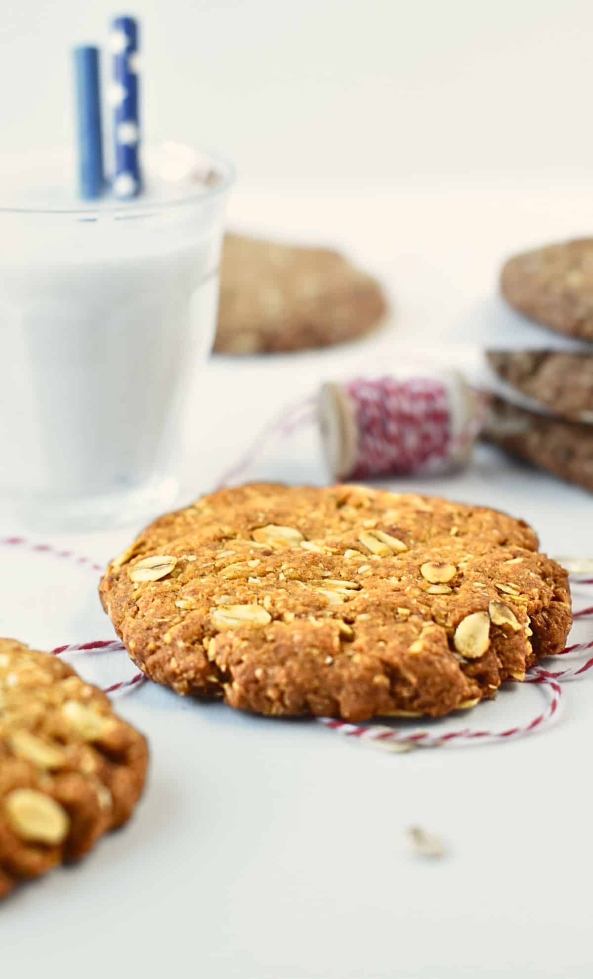 Anzac Biscuits in front of a glass of plant-based milk.