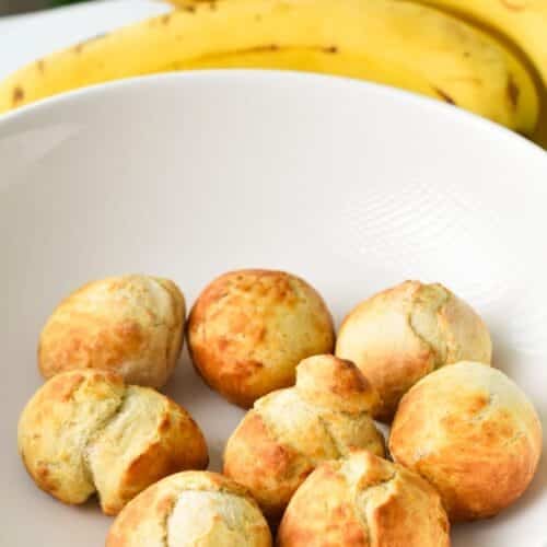 Air-fried banana donut holes in a bowl before being coated with cinnamon sugar.