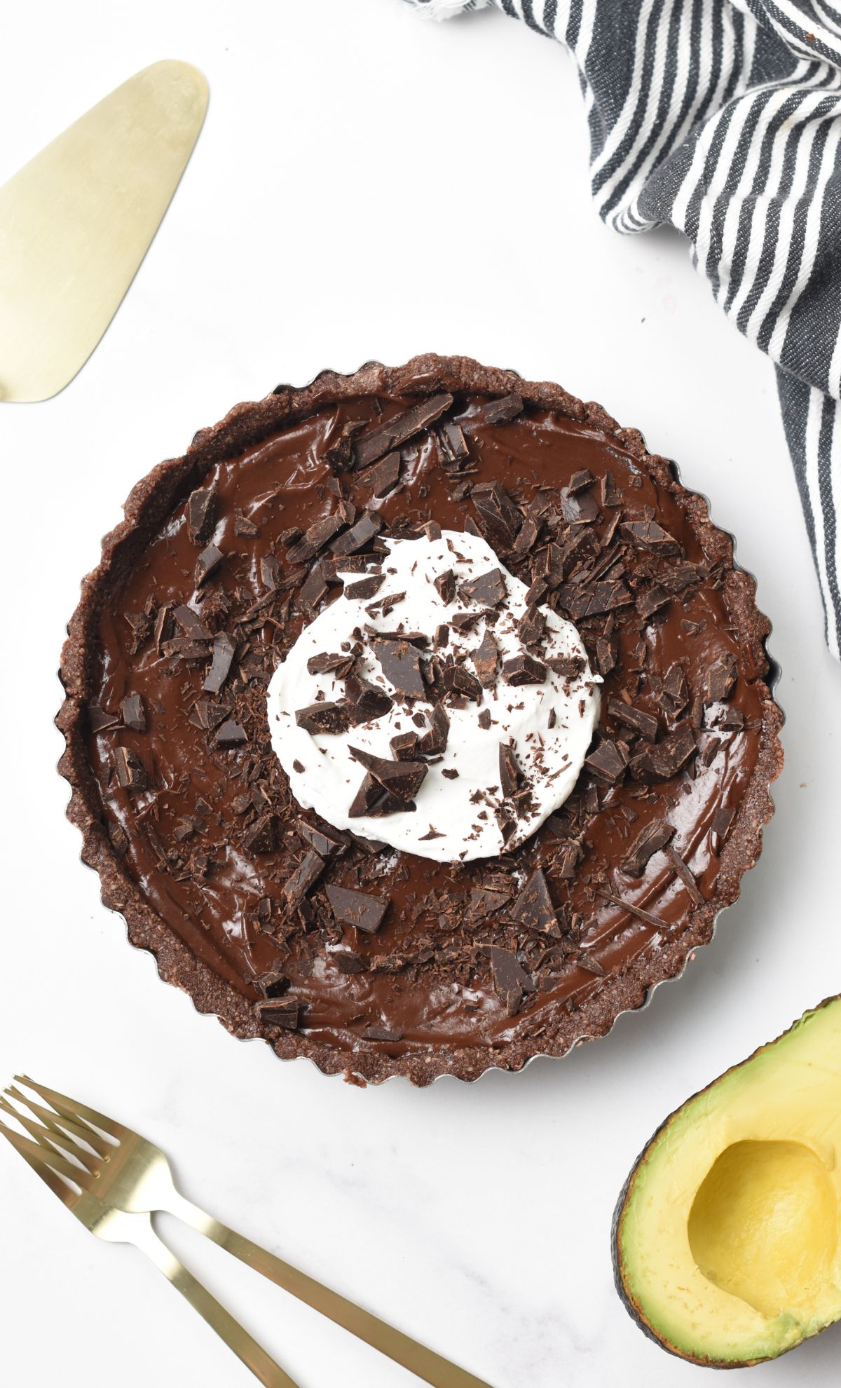 Chocolate Avocado Pie decorated with coconut yogurt and dark chocolate chunks.