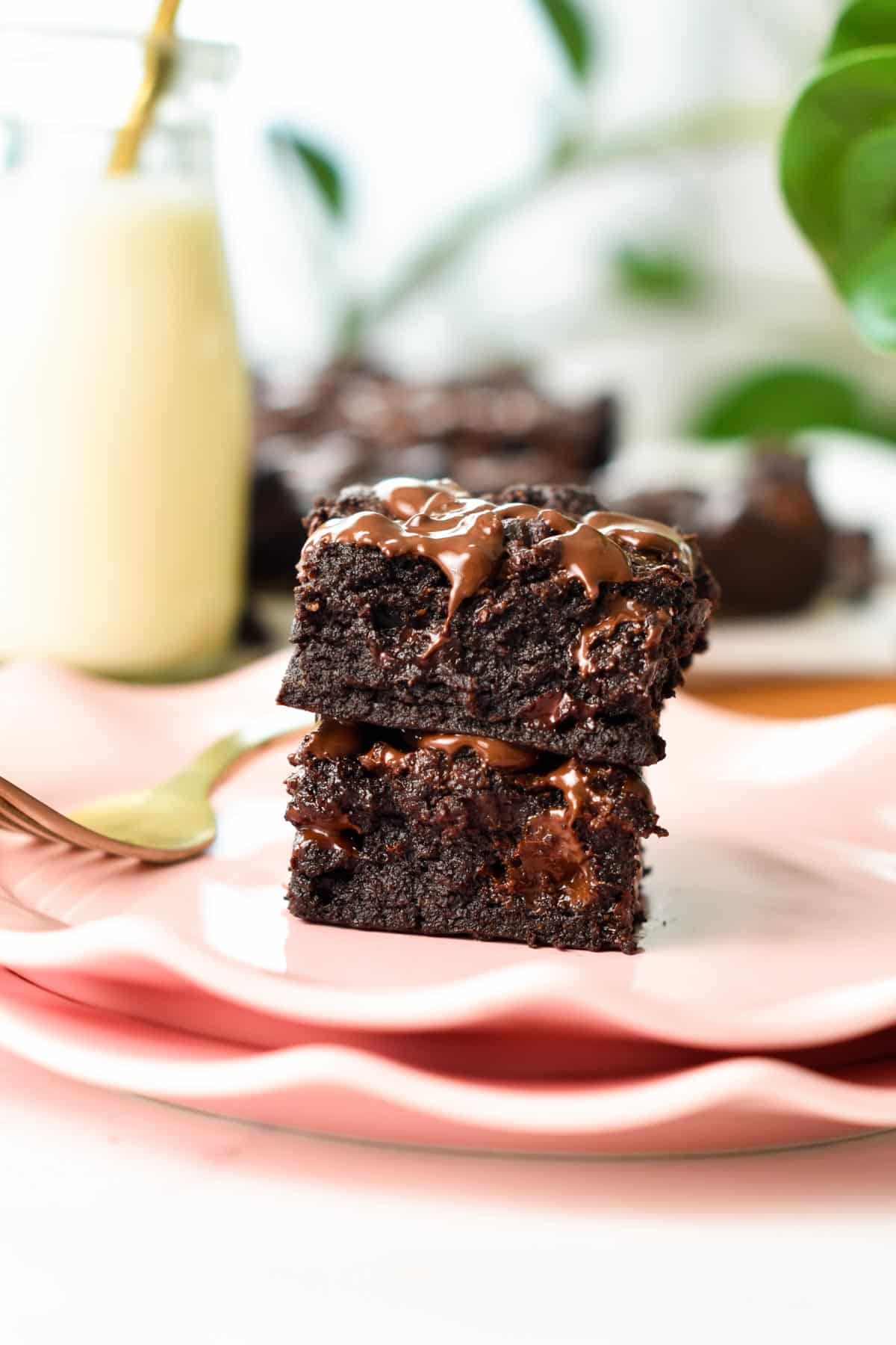 A stack of two squares of healthy brownies with melted chocolate chips.