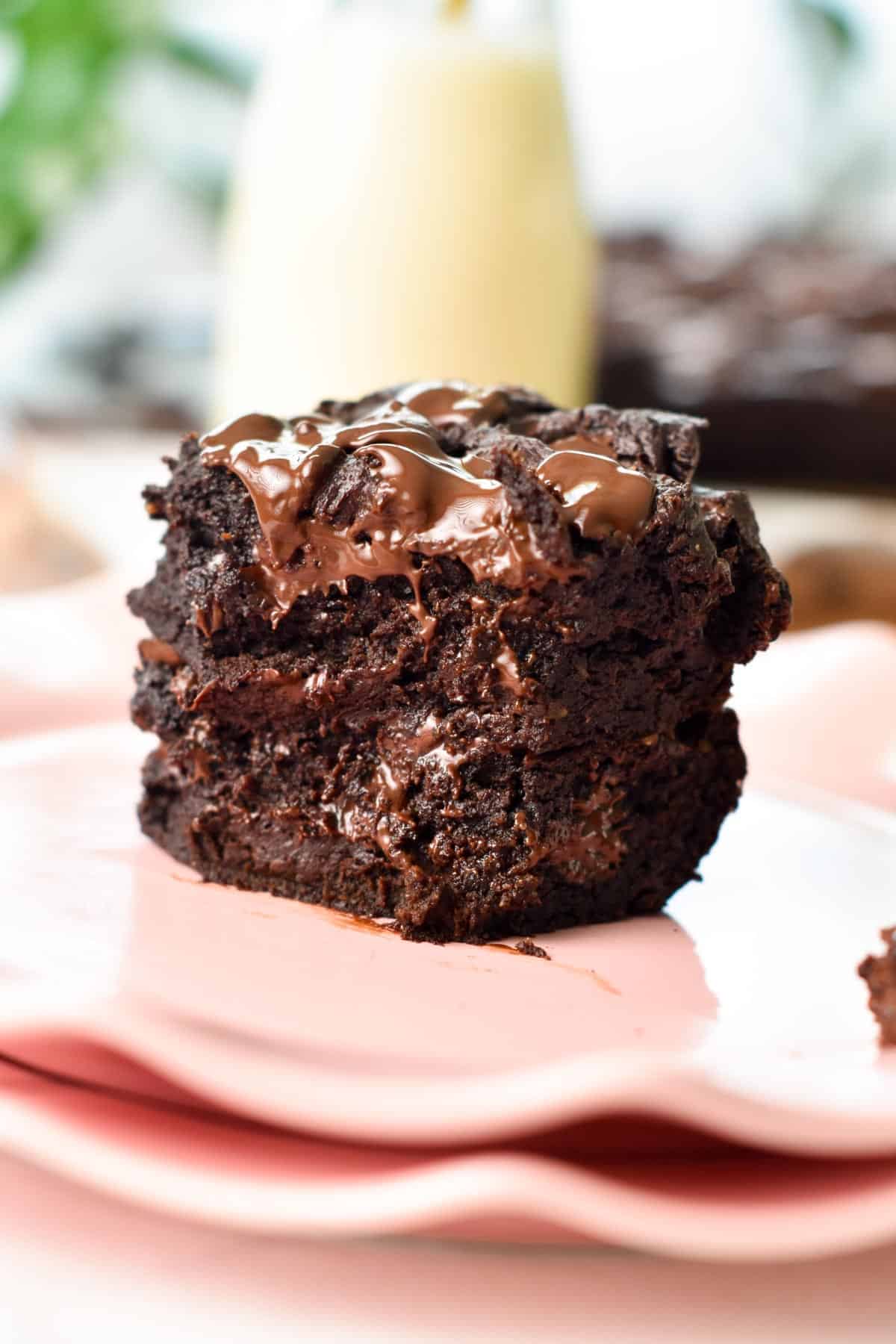 A stack of two pieces of healthy brownies cut in the front to show the ultra-fudgy texture.