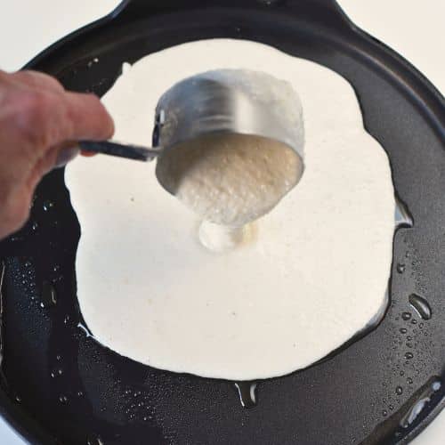 Pouring the paleo tortilla batter onto a pan.