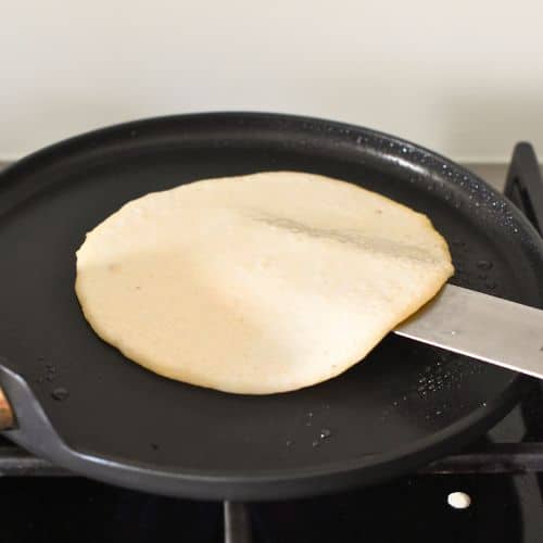 Flipping the paleo tortilla on a pan.