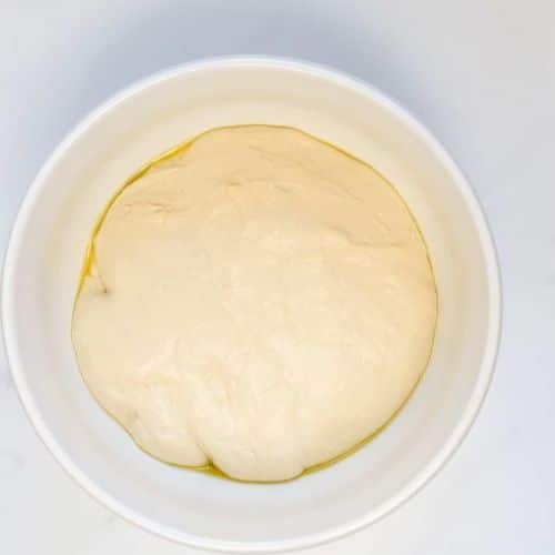 Vegan pizza dough in a bowl before it rises.