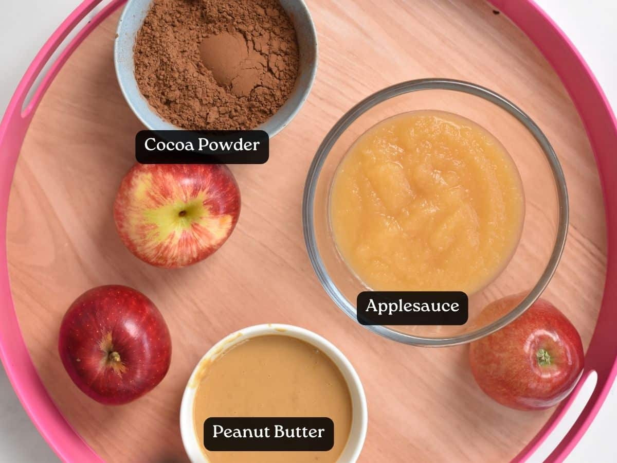Ingredients for Applesauce Brownies in small bowls on a serving tray with fresh apples.