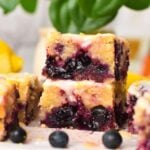 a stack of three pieces of lemon blueberry blondies with icing