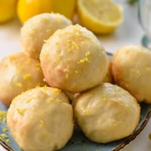 a stack of lemon donut holes glazed with lemon icing and lemon zest on top