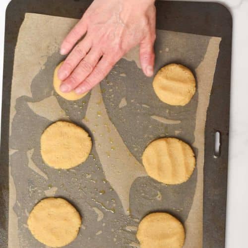 Flattening 2-ingredient cookie on a baking sheet.