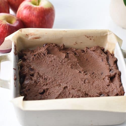 Spreading applesauce brownie batter in a baking pan.