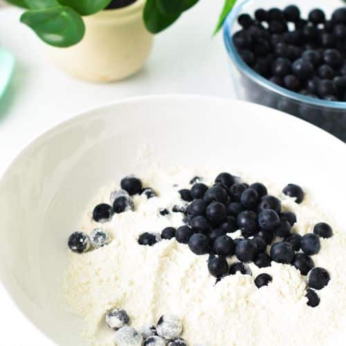 Blueberries and almond flour in a mixing bowl.