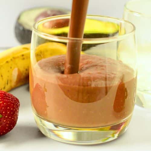 Pouring Banana Strawberry Chocolate Smoothie into a glass.