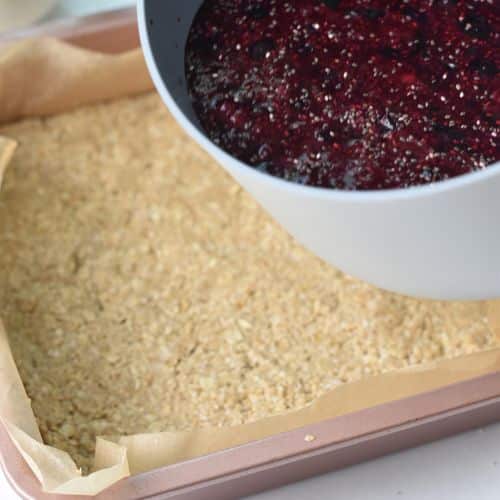 Pouring the jam on the Blueberry Breakfast Bars base.