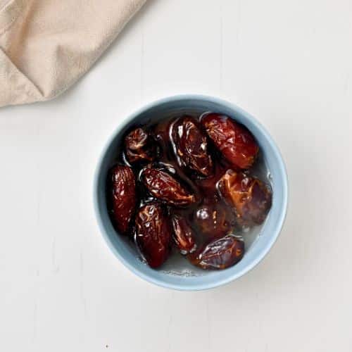 Soaking dates in a small blue bowl.