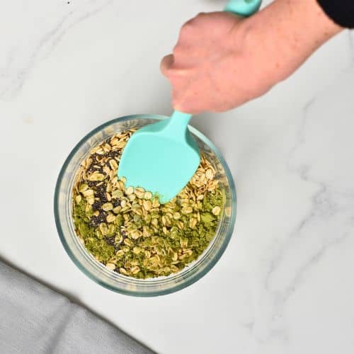 Combining dry Matcha overnight oat ingredients in a bowl.
