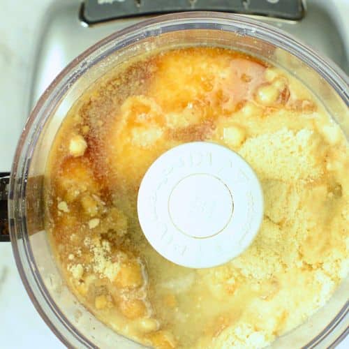 Combining the no-bake coconut cookie ingredients in the bowl of a food processor.