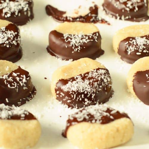 No-Bake Coconut Cookies on a cookie sheet decorated with chocolate and shredded coconut.